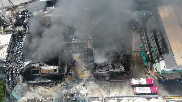 Aerial view overlooking firefighters extinguishing a house on fire, sunny day, in Port-Au-Prince, Ha