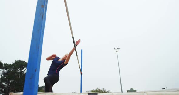 Low angle view of Caucasian female athlete practicing high jump at sports venue 4k