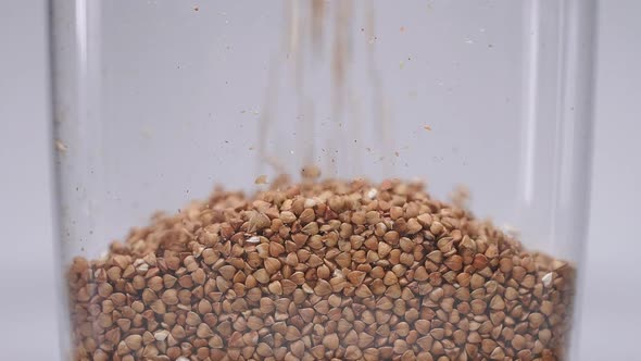 Close-up of Buckwheat Poured Into a Jar for Storage. Useful Food During the Quarantine Period, the