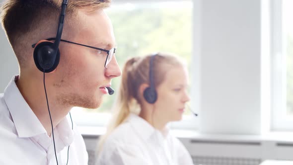 Diverse team of young professionals is working in the phone support office.