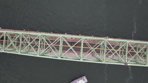 An aerial view of the Fire Island Inlet Bridge during a cloudy morning over calm waters. The camera