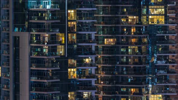 Glowing Windows in Multistory Modern Glass Residential Building Light Up at Night Timelapse