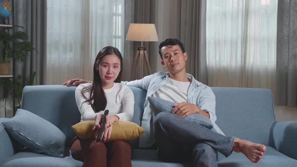 Young Asian Couple Relaxing And Watching Tv At Home
