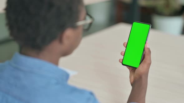 Young African Man Using Smartphone with Green Screen