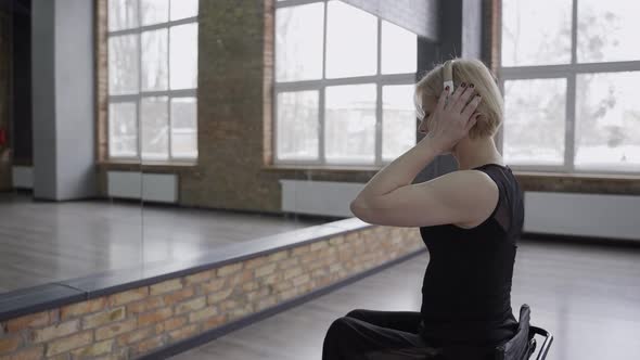 Disabled Woman in Headphones Dancing in Ballroom