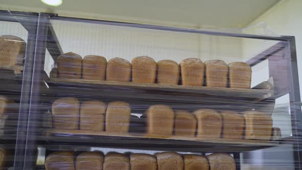 Bread on Shelves Under Cling Film. Freshly Baked Bread Trays in a Row. The Bread Is Stored in a