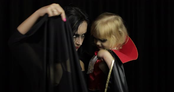 Woman and Child Dracula. Halloween Vampire Make-up. Kid with Blood on Her Face