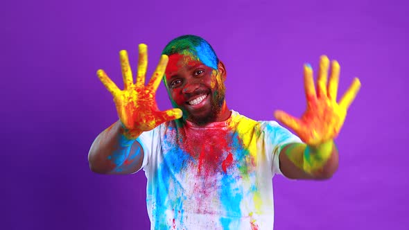 Afro American Man Celebrate Holi Festival in Violet Studio Background