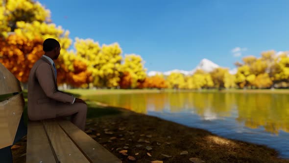 Businessman Sit On Edge Of Lake In Park