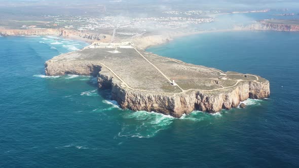 Cape Sagres Portugal with Sagres Fortress and lighthouse on top of the eroding coast, Aerial dolly r