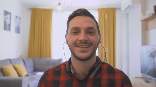 POV Shot of Young Man Working From Home with Earphones and Webcam