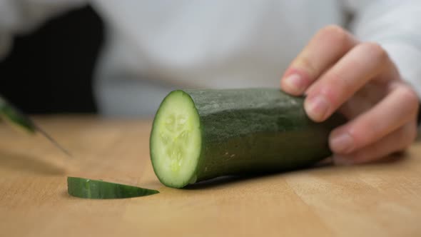 Cutting cucumber into slices with a sharp knife