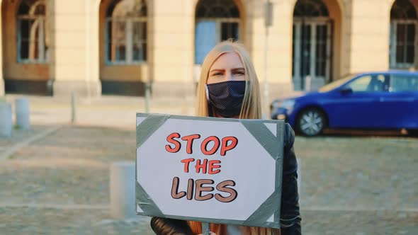 Concerned Woman in Mask with Protest Banner Calling to Stop Lies
