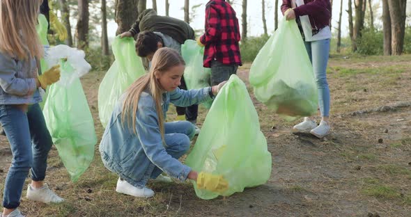 Activists which Together Picking Up Trash Into Plastic Bags in the Park