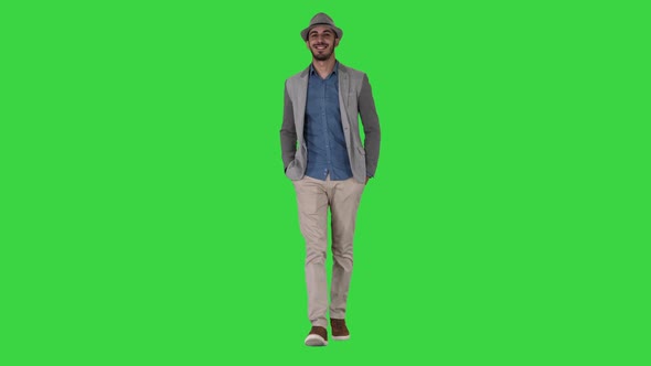 Young Asian Tourist Man Wearing Hat Walking with Hands in Pockets on a Green Screen, Chroma Key.