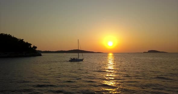 Sunset in Croatia with boat sailing past. Beautiful cinematic aerial footage