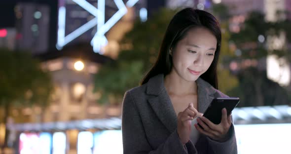 Business woman working on smart phone at night