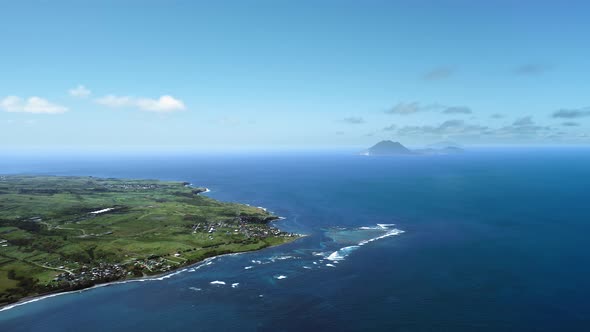 Aerial footage of settlements, the sea and the shadow of a mountain in Saint Kitts and Nevis