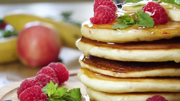 Pouring Honey on Stack of Pancakes