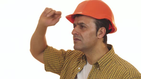 Mature Professional Builder in Hardhat Looking Disappointed