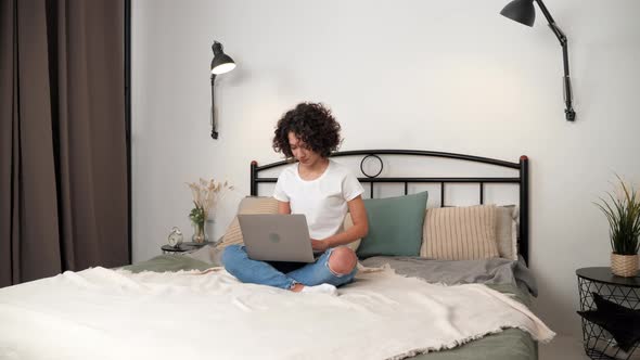 Smiling Hispanic Curly Woman Student Study Uses Laptop Distance Education