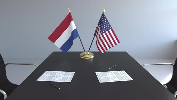 Flags of the Netherlands and the USA on the Table alt