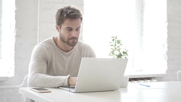 Businessman Leaving Office After Closing Laptop at Work