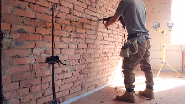 A construction worker works with a puncher close up.