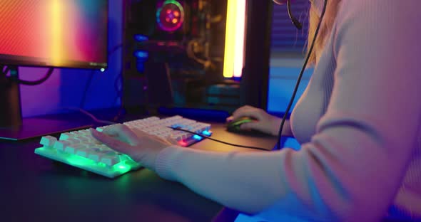 Close up gamer hands actively pushing buttons with colorful neon LED lights