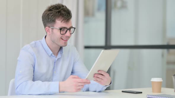 Young Man Making Video Call on Tablet in Office