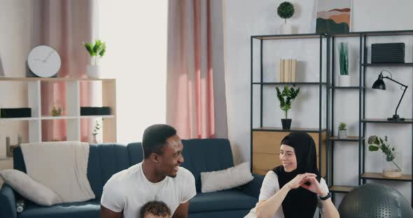 Multiethnic Couple with Small Son which Squating Together During Home Training