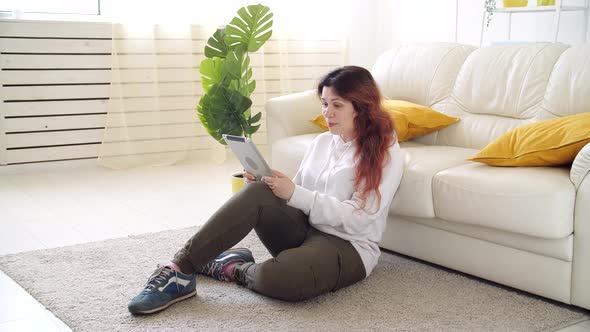 Self Isolation Concept. Young Woman Sitting on a Sofa in the Living Room and Talking Via Video Call.
