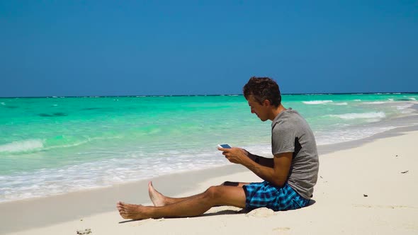 Man with Cellphone on the Tropical Beach