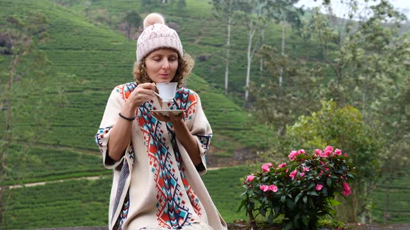 Woman Drinking Tea With Mountain View On Tea Plantation