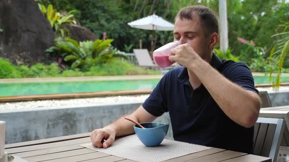 Happy Handsome Man Drinking Freshly Smoothie From Fresh Fruit and Berries