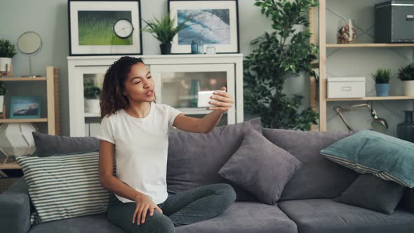 Young African American Lady Is Calling Friends on Skype Making Online Video Call with Smartphone