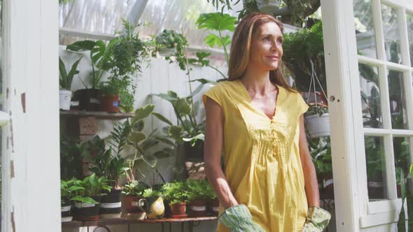 Woman smiling and looking at camera in a greenhouse
