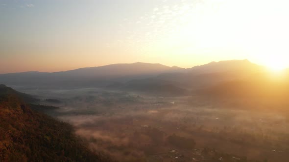 Aerial view from a drone over misty landscape on farmland. 4K