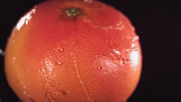 Super Slow Motion Water Drips on Rotating Grapefruit