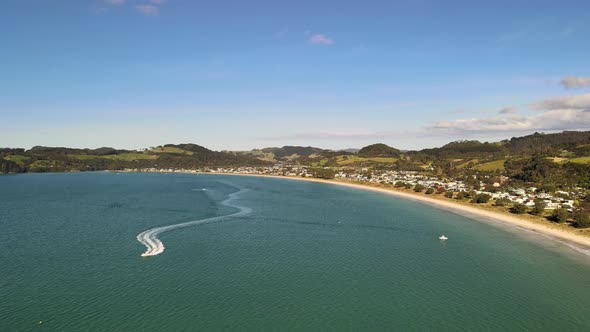 Power boat on a summers day cruising through the waters of Coromandel in Cooks bay - Drone flight ba