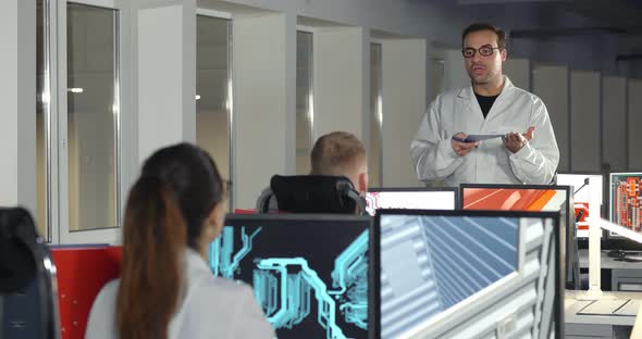 Engineer Announcing News To Colleagues in Scientific Office