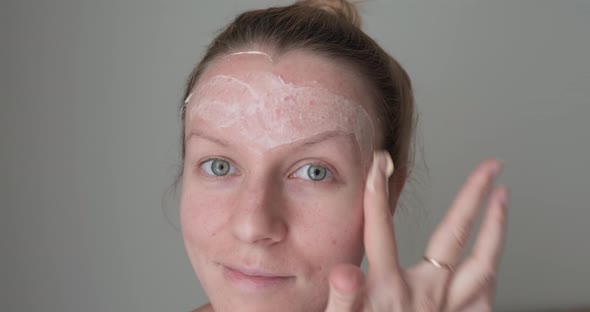 Woman applying hydration mask on face