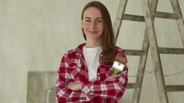 Woman Paints Walls at Home Holds Paint Brush