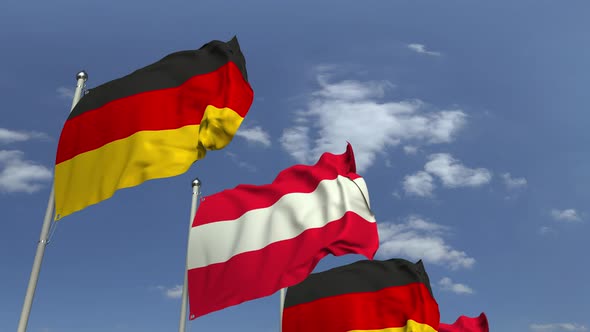 Waving Flags of Austria and Germany on Sky Background