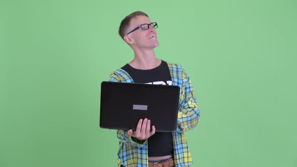 Portrait of Happy Nerd Man Thinking While Using Laptop