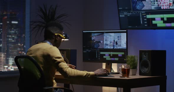 Young Man Sitting Back and Editing Video Inside a Room