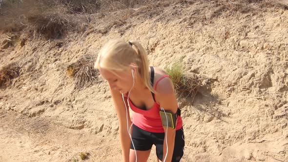 A young woman runner taking a break from her run to catch her breath.