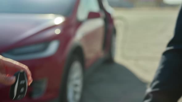 Female Seller Giving Keys From Electric Car to Male Client