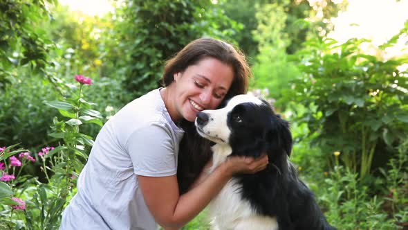 Smiling Young Attractive Woman Playing with Cute Puppy Dog Border Collie on Summer Outdoor