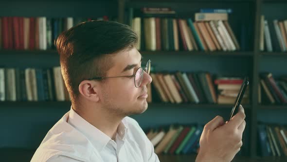 Human in Library with Cellphone